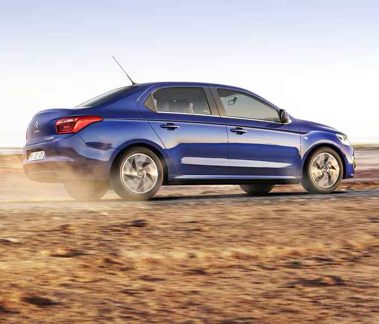 Вигляд з правого боку на Citroën C-Elysée, що мчить по грунтовій дорозі