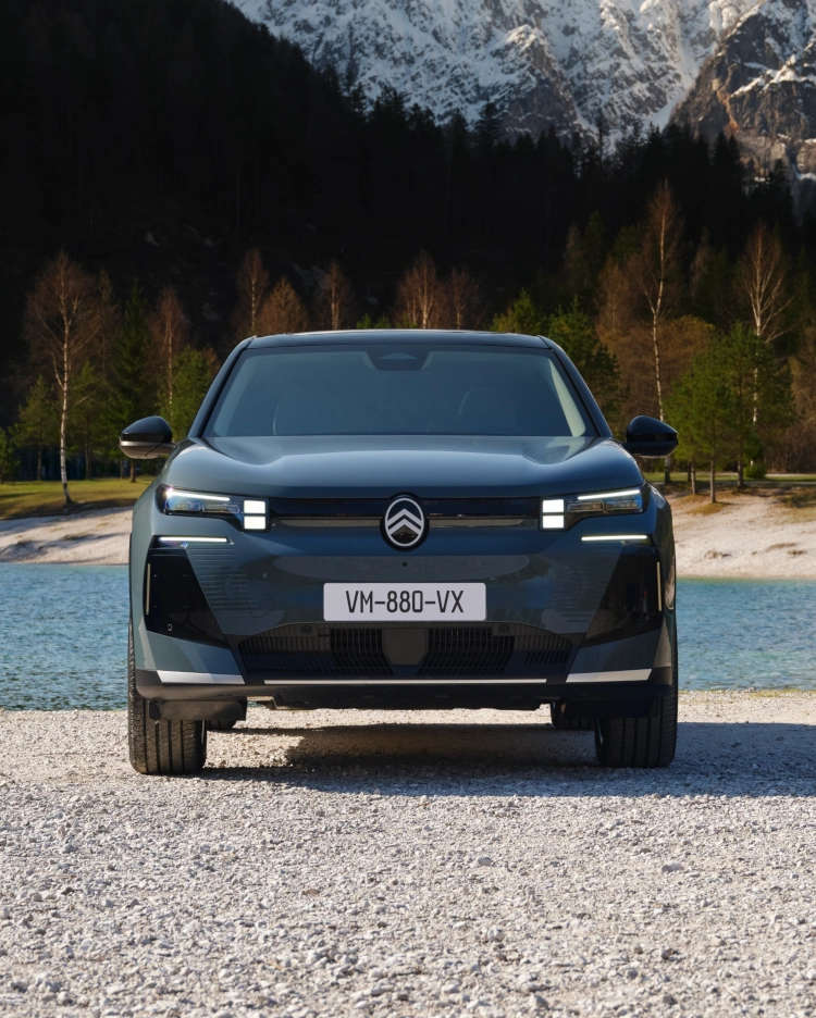 Синій Citroën C5 Aircross біля озера з дівчиною й хлопцем обабіч, вигляд спереду